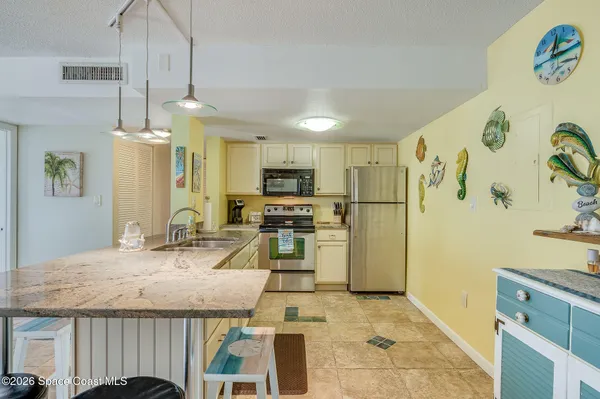 a kitchen with granite countertop a refrigerator a stove a microwave oven a sink and dishwasher