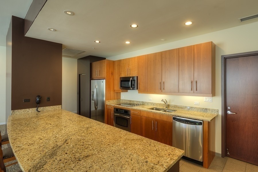 807 Davis Street, Unit 1710 Evanston, IL 60201 - Photo 14 of 21 a kitchen with stainless steel appliances granite countertop a sink a stove and a refrigerator