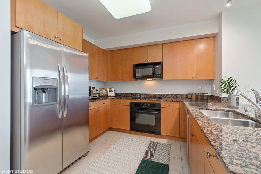 807 Davis Street, Unit 1710 Evanston, IL 60201 - Photo 2 of 21 a kitchen with stainless steel appliances granite countertop a refrigerator a stove and a sink with wooden floor