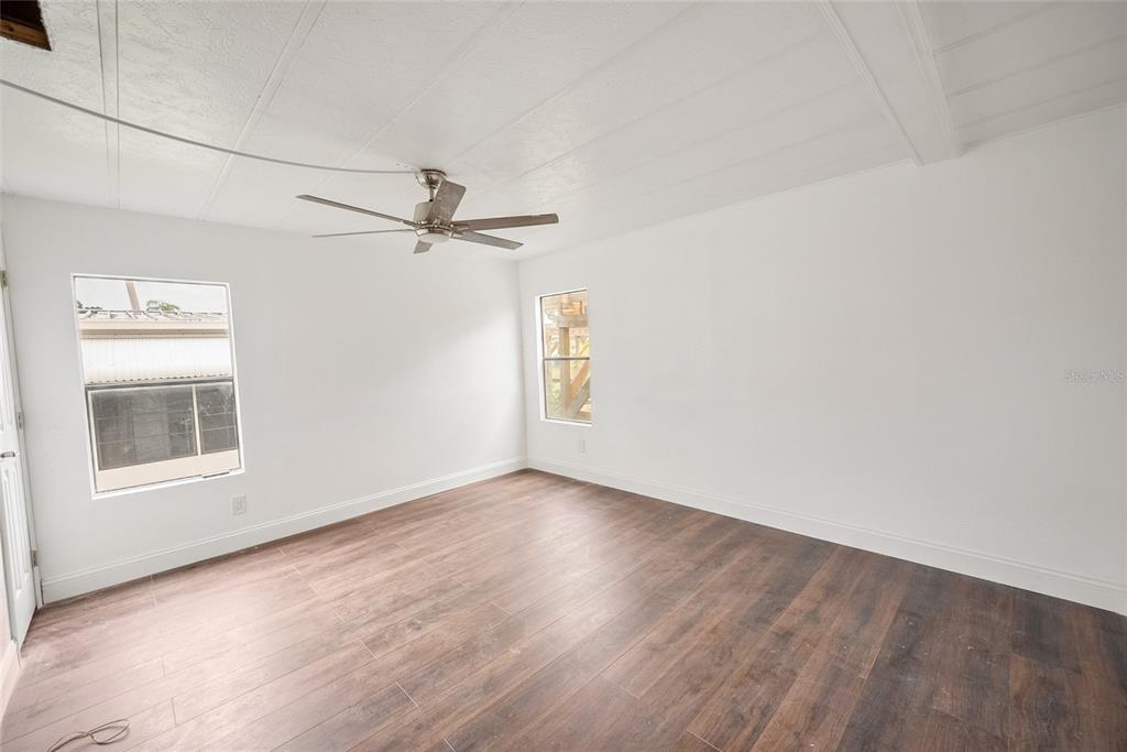 4434 Tucker Square New Port Richey, FL 34652 - Photo 14 of 37 an empty room with wooden floor fan and windows