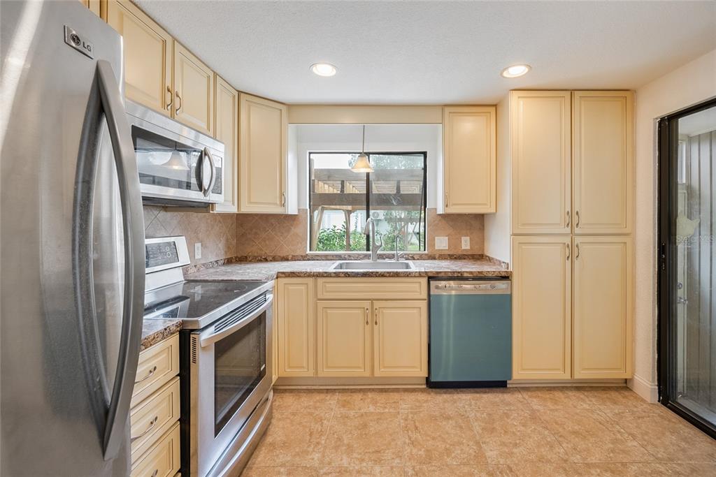 4434 Tucker Square New Port Richey, FL 34652 - Photo 5 of 37 a kitchen with stainless steel appliances granite countertop a refrigerator and a stove top oven