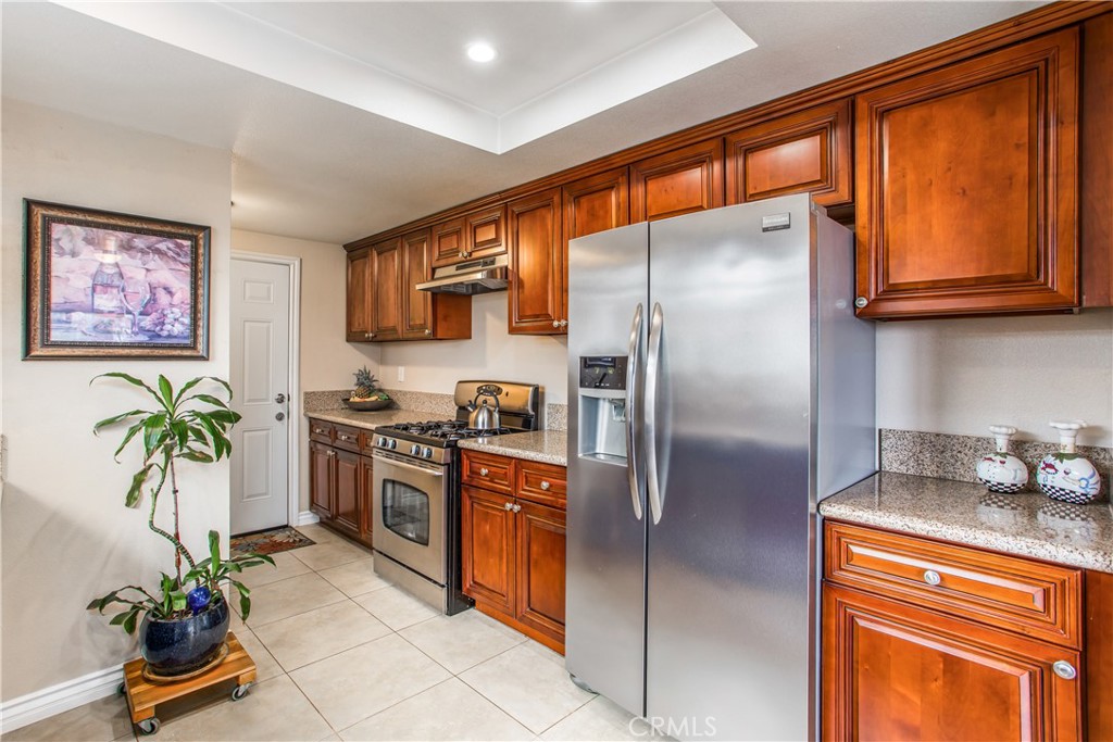3396 Spring Garden Street Riverside, CA 92501 - Photo 11 of 28 a kitchen with granite countertop stainless steel appliances a counter top space cabinets and a window