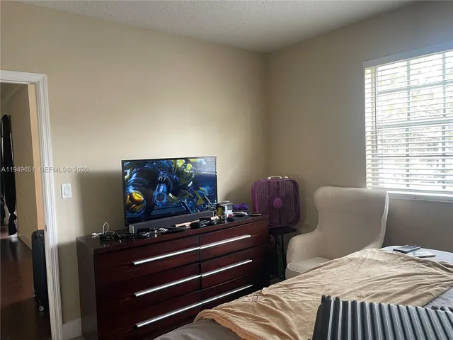 a bedroom with a bed and a flat screen tv