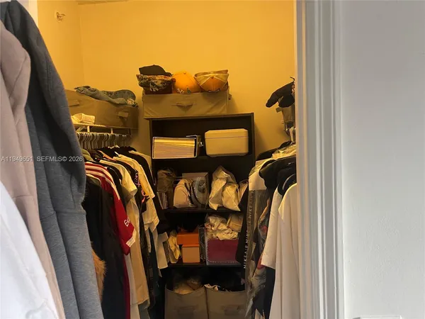 a view of walk in closet with clothes and shoes