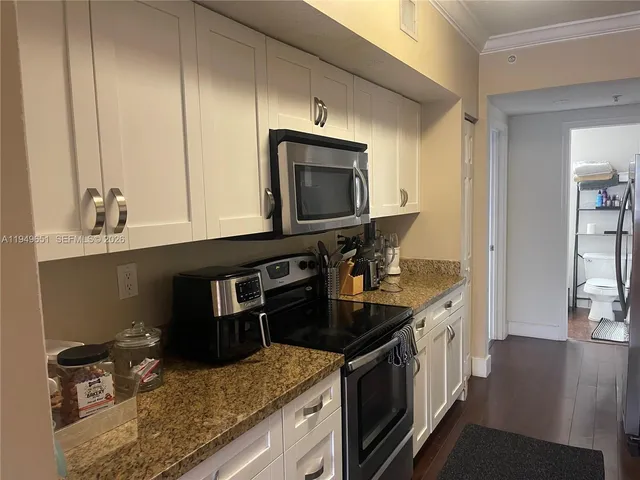 a kitchen with stainless steel appliances granite countertop a sink stove and cabinets