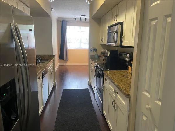 a kitchen with granite countertop a refrigerator and a stove