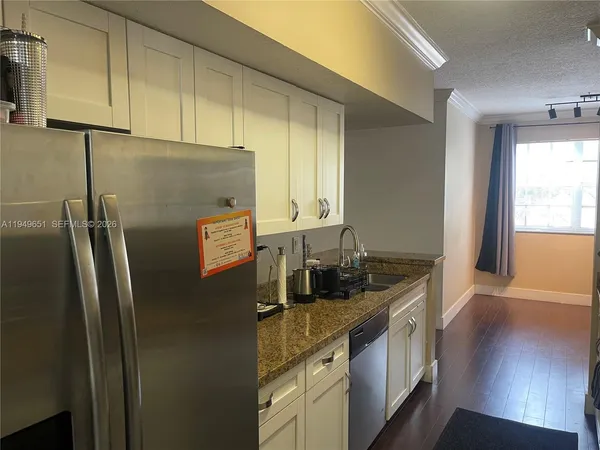 a kitchen with stainless steel appliances granite countertop a refrigerator and a sink