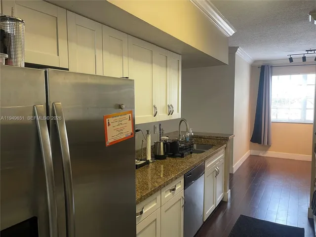 a kitchen with stainless steel appliances granite countertop a refrigerator and a sink