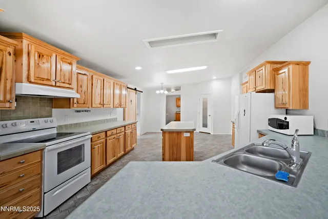 a kitchen with stainless steel appliances granite countertop a sink stove and cabinets