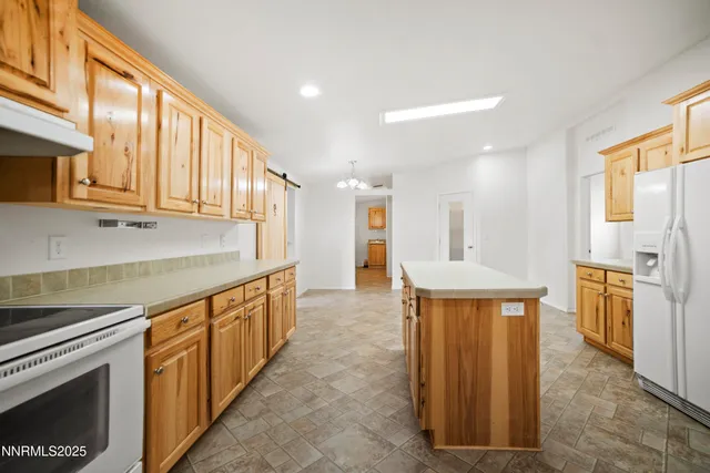 a kitchen with stainless steel appliances granite countertop a refrigerator a stove and a sink