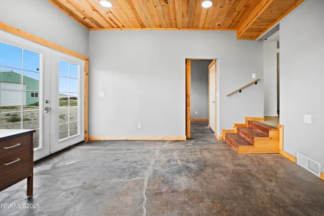 a view of an empty room with furniture and a window