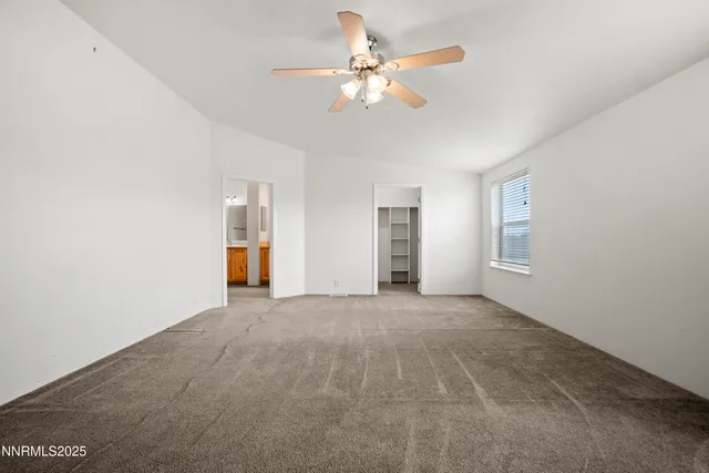 a view of an empty room with a ceiling fan