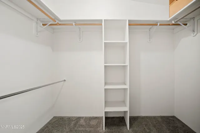a view of walk in closet with empty racks