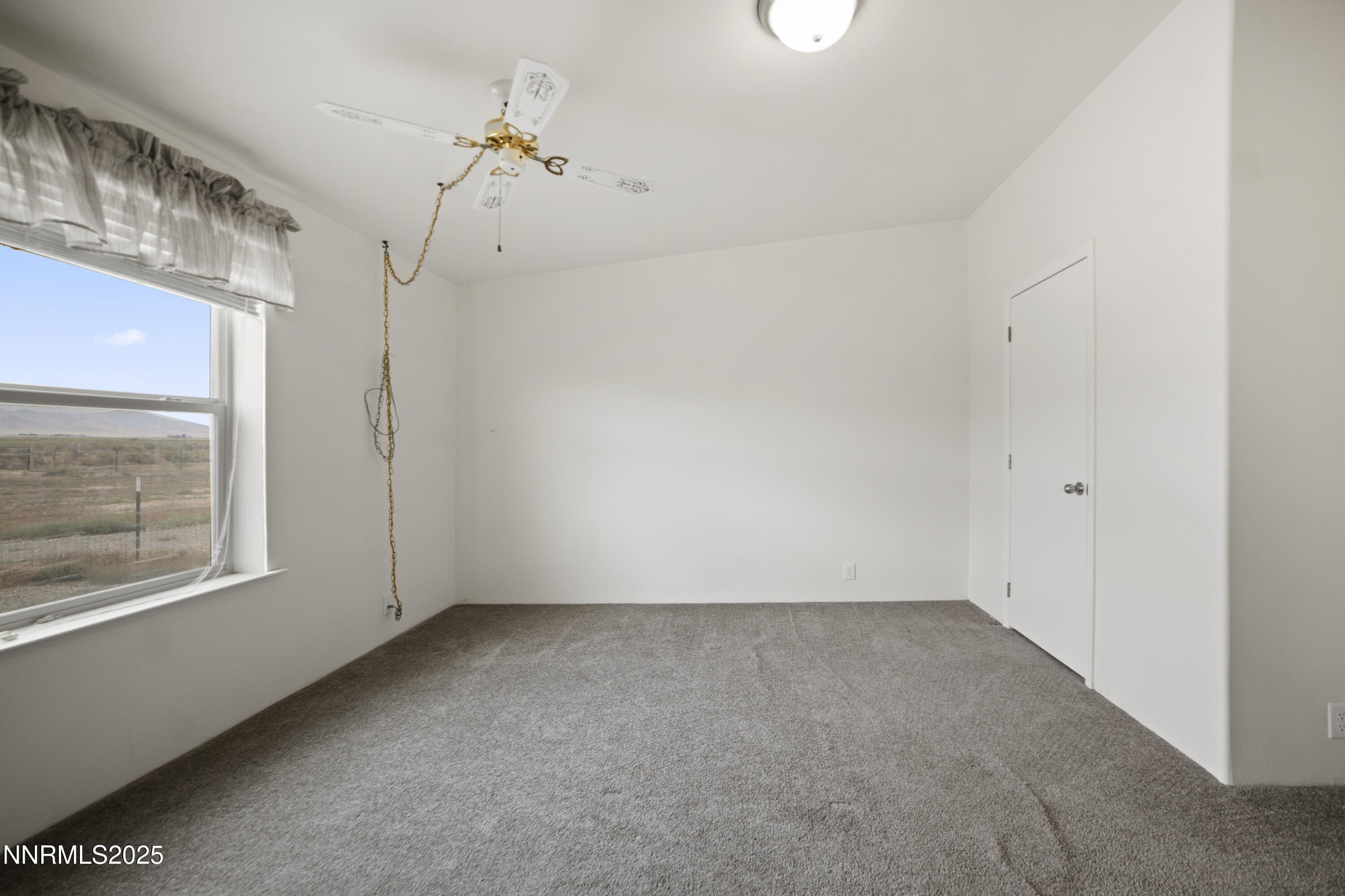 3900 Van Diest Road Winnemucca, NV 89445 - Photo 30 of 45 an empty room with a window and a ceiling fan