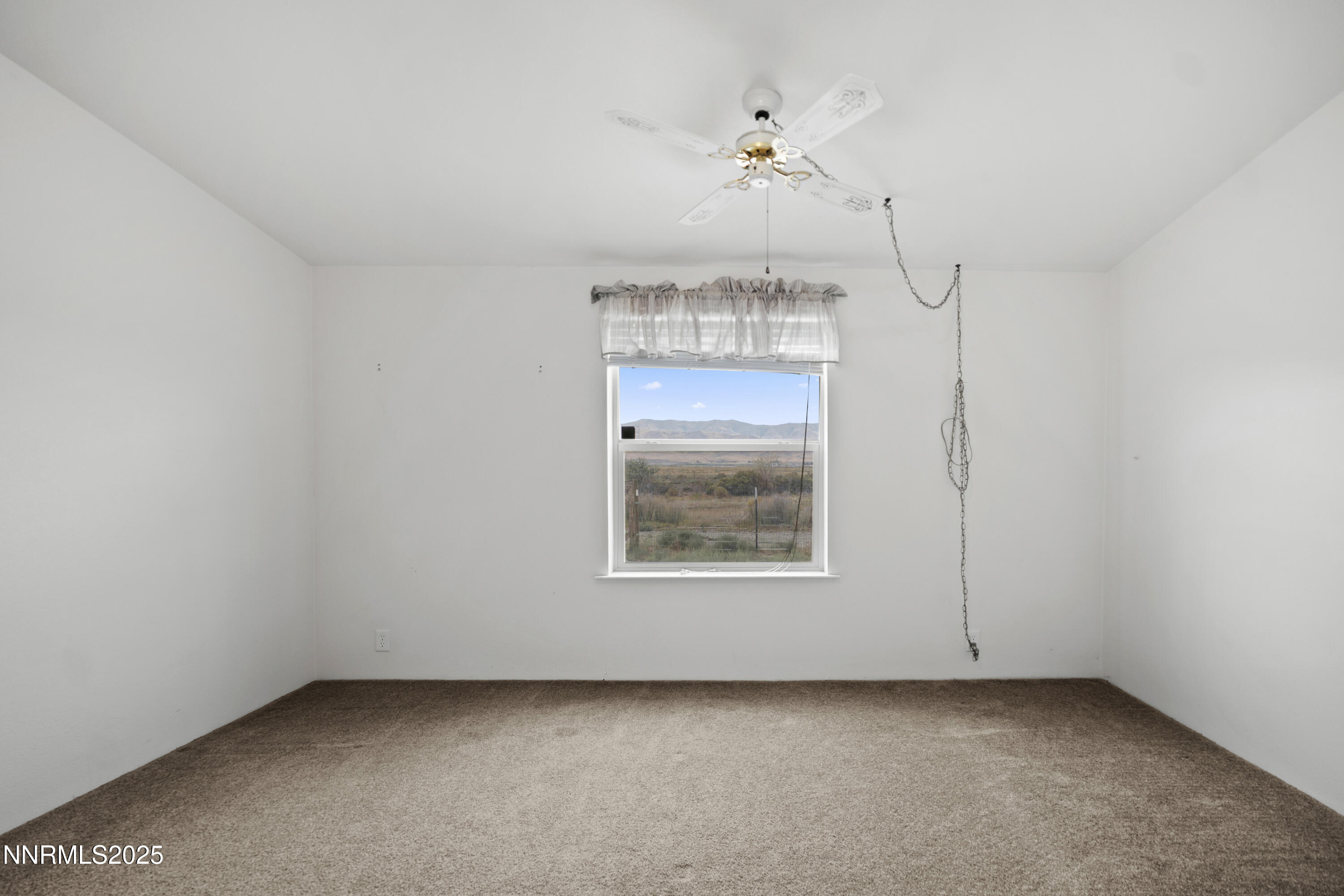 3900 Van Diest Road Winnemucca, NV 89445 - Photo 31 of 45 an empty room with a chandelier fan and wooden floor