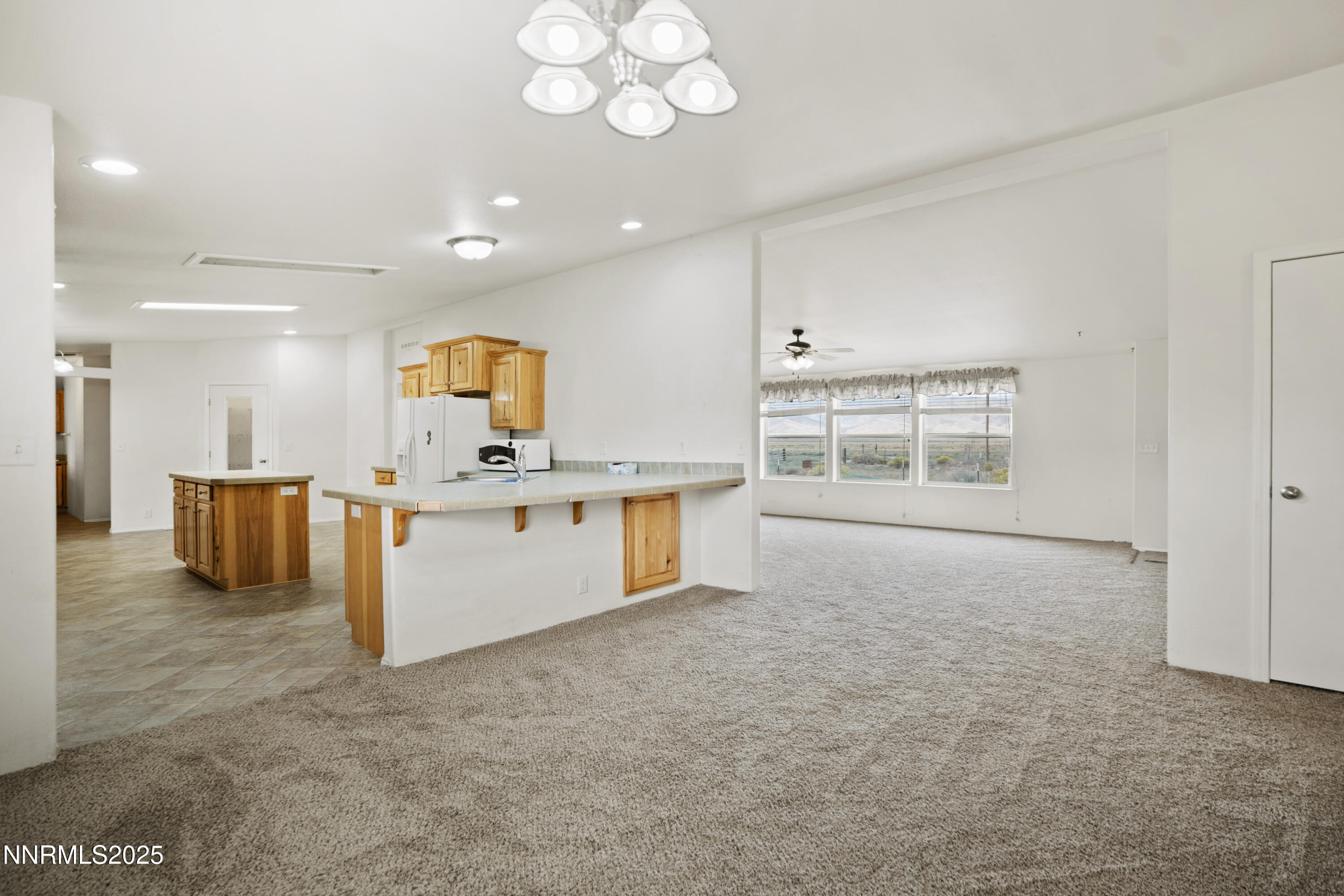 3900 Van Diest Road Winnemucca, NV 89445 - Photo 10 of 45 a large white kitchen with kitchen island a large counter space a sink and appliances