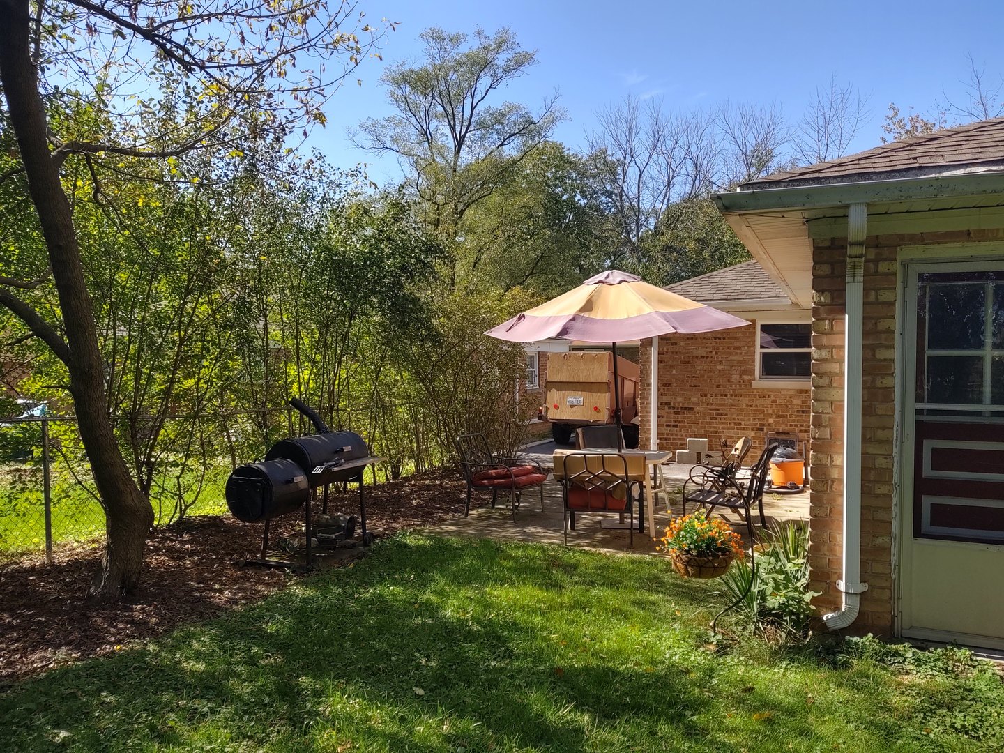17643 Dundee Avenue Homewood, IL 60430 - Photo 20 of 27 a view of a patio with furniture and a table and chairs under an umbrella