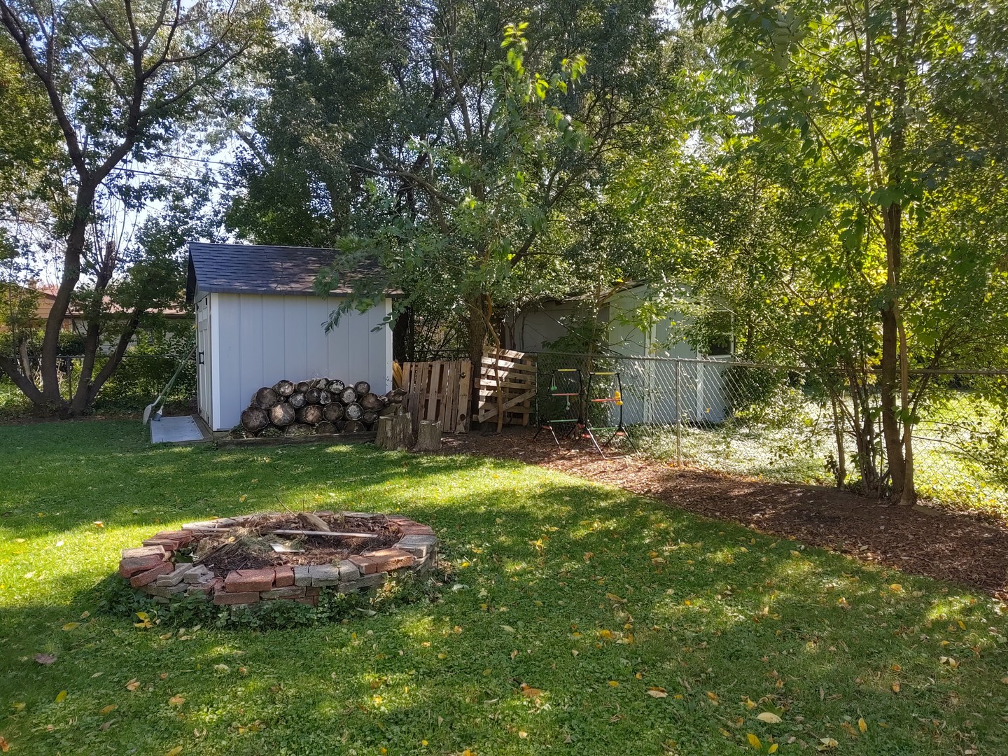17643 Dundee Avenue Homewood, IL 60430 - Photo 22 of 27 a view of a backyard with table and chairs and a large tree