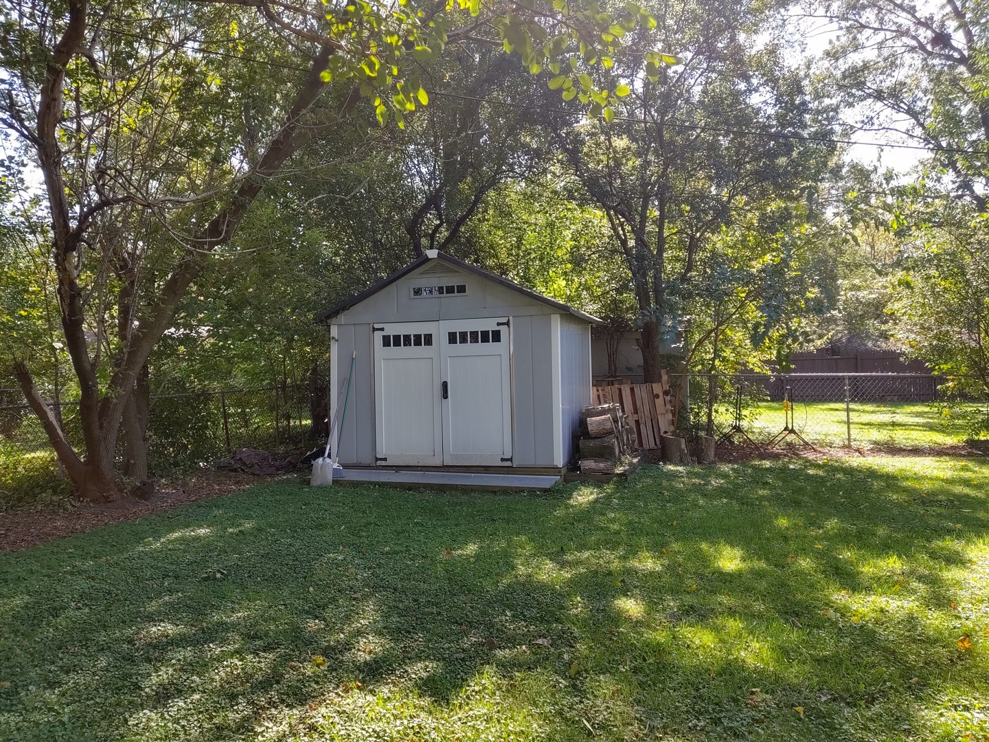 17643 Dundee Avenue Homewood, IL 60430 - Photo 24 of 27 a view of a wooden house with a big yard and large trees