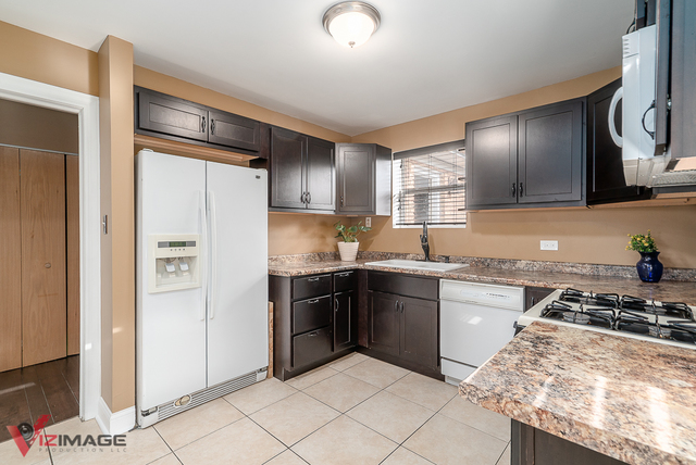 17643 Dundee Avenue Homewood, IL 60430 - Photo 7 of 27 a kitchen with granite countertop stainless steel appliances and wooden cabinets