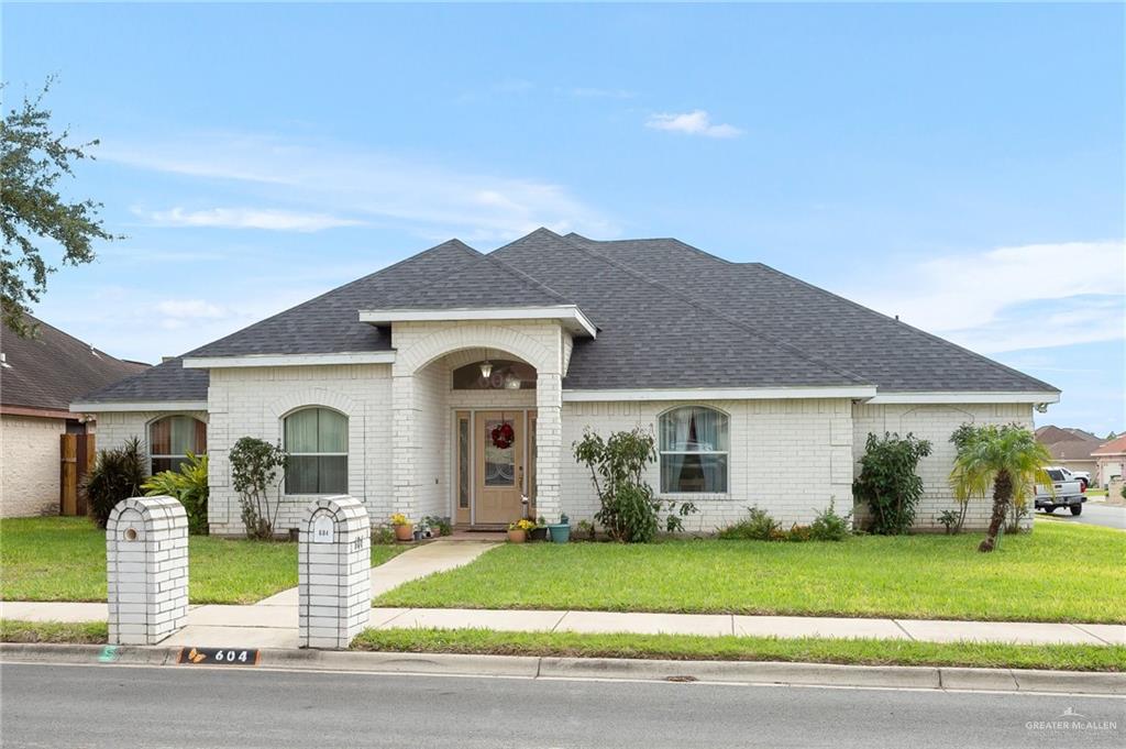 a front view of a house with a garden and plants