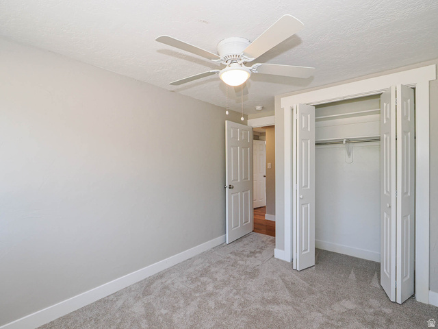 154 East 3000th Street South Bountiful, UT 84010 - Photo 20 of 37 Neutral-toned room featuring light gray walls, plush carpet flooring, a ceiling fan with integrated lighting, and a bi-fold closet with white trim