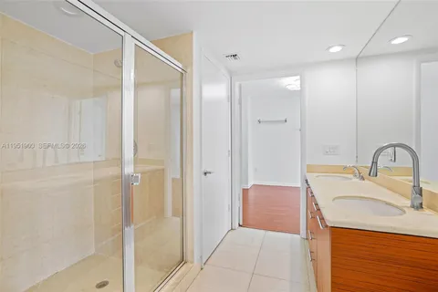 a bathroom with a granite countertop sink a toilet and shower