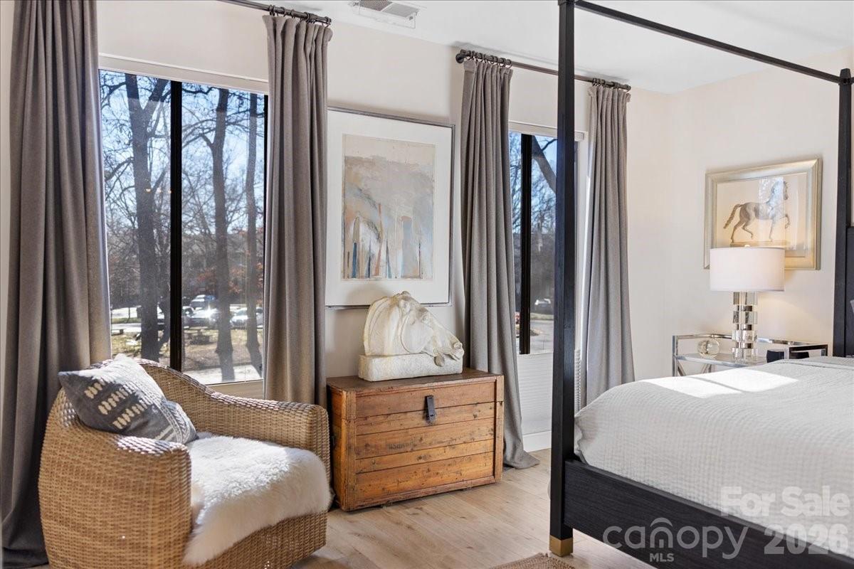 5801 Sharon Road, Unit J Charlotte, NC 28210 - Photo 26 of 46 a bedroom with a large bed and a chandelier