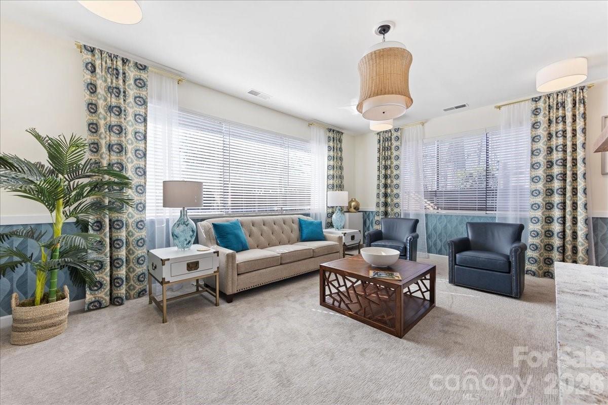 5801 Sharon Road, Unit J Charlotte, NC 28210 - Photo 45 of 46 a living room with furniture a chandelier and a large window