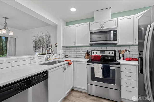 a kitchen with stainless steel appliances a sink stove and refrigerator