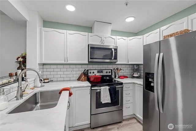 a kitchen with stainless steel appliances a refrigerator sink and microwave