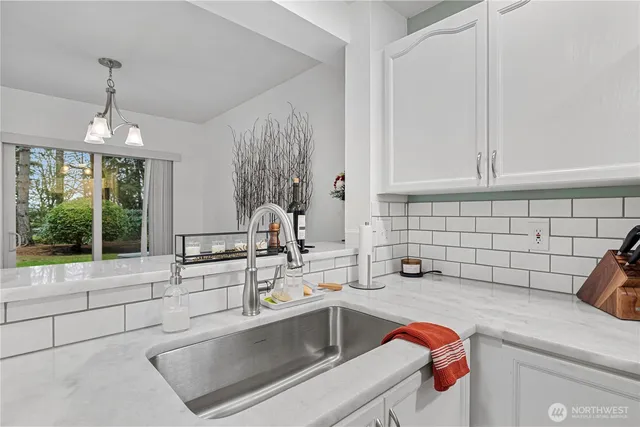 a kitchen with a sink and a stove next to a window