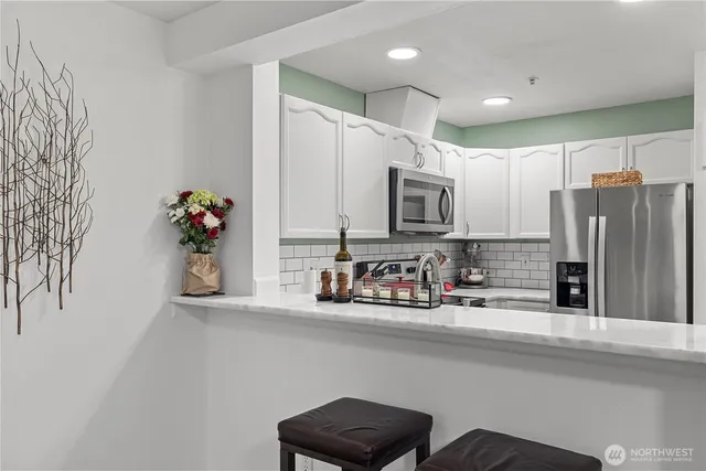 a kitchen with stainless steel appliances a sink and a refrigerator
