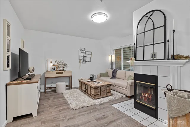 a living room with furniture a flat screen tv and a fireplace