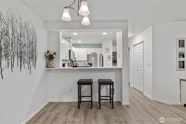 a living room with stainless steel appliances kitchen island granite countertop furniture a rug and a kitchen view