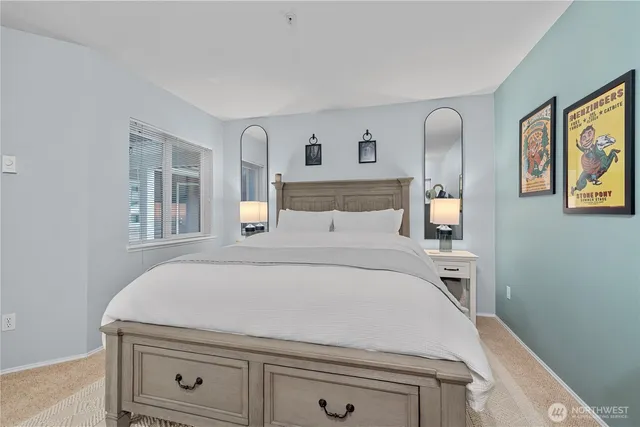 a bed room with a bed and a painting on the wall