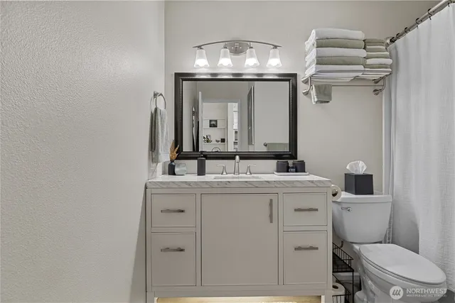 a bathroom with a toilet a sink and mirror