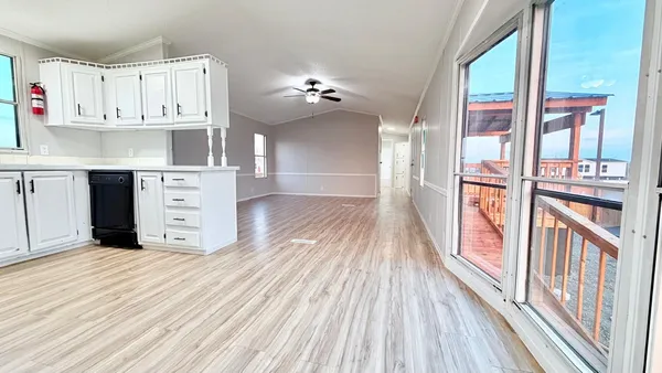 a view of a kitchen with wooden floor and cabinets