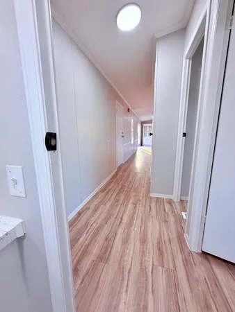 a view of a hallway with wooden floor and staircase