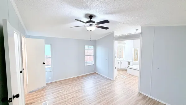 a view of a room with wooden floor and a ceiling fan