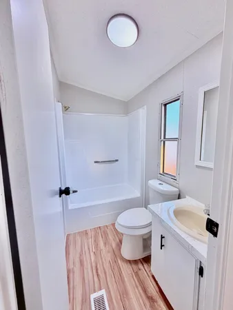 a bathroom with a sink toilet a mirror and shower