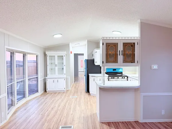 a living room with stainless steel appliances wooden floor and a window