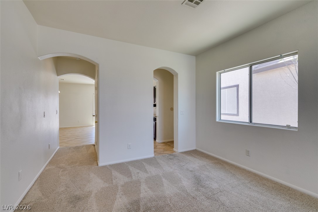 5150 Riverside Run Court North Las Vegas, NV 89081 - Photo 10 of 50 Sun-drenched interiors flow seamlessly through arched doorways, connecting spacious living areas.
