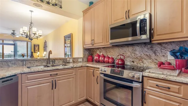 a kitchen with stainless steel appliances granite countertop a sink stove and microwave