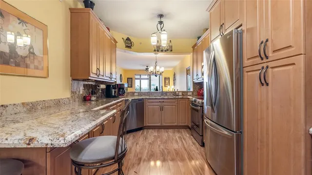 a kitchen with stainless steel appliances granite countertop a sink a stove and cabinets
