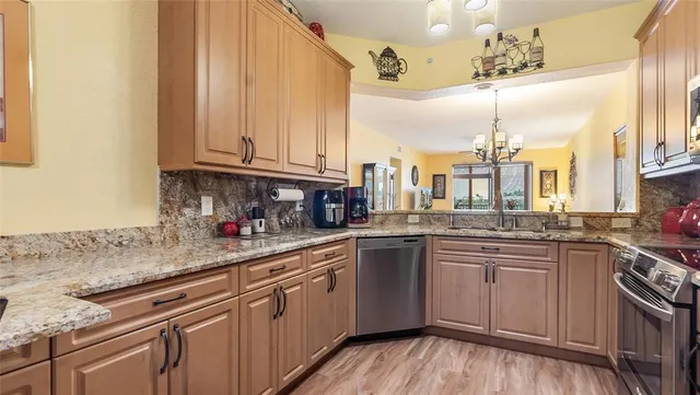 a kitchen with stainless steel appliances granite countertop lots of counter top space and wooden floor