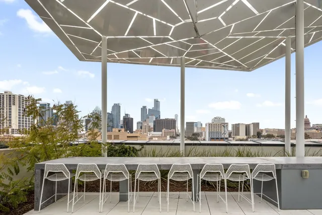 a white table sitting next to a glass top table and chairs