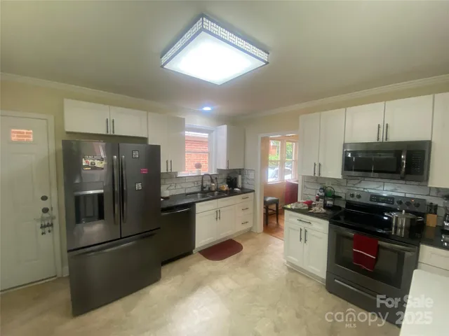 a kitchen with stainless steel appliances granite countertop a stove refrigerator sink and microwave