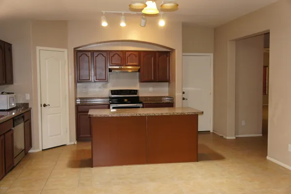 a room with kitchen island stainless steel appliances a stove and a refrigerator