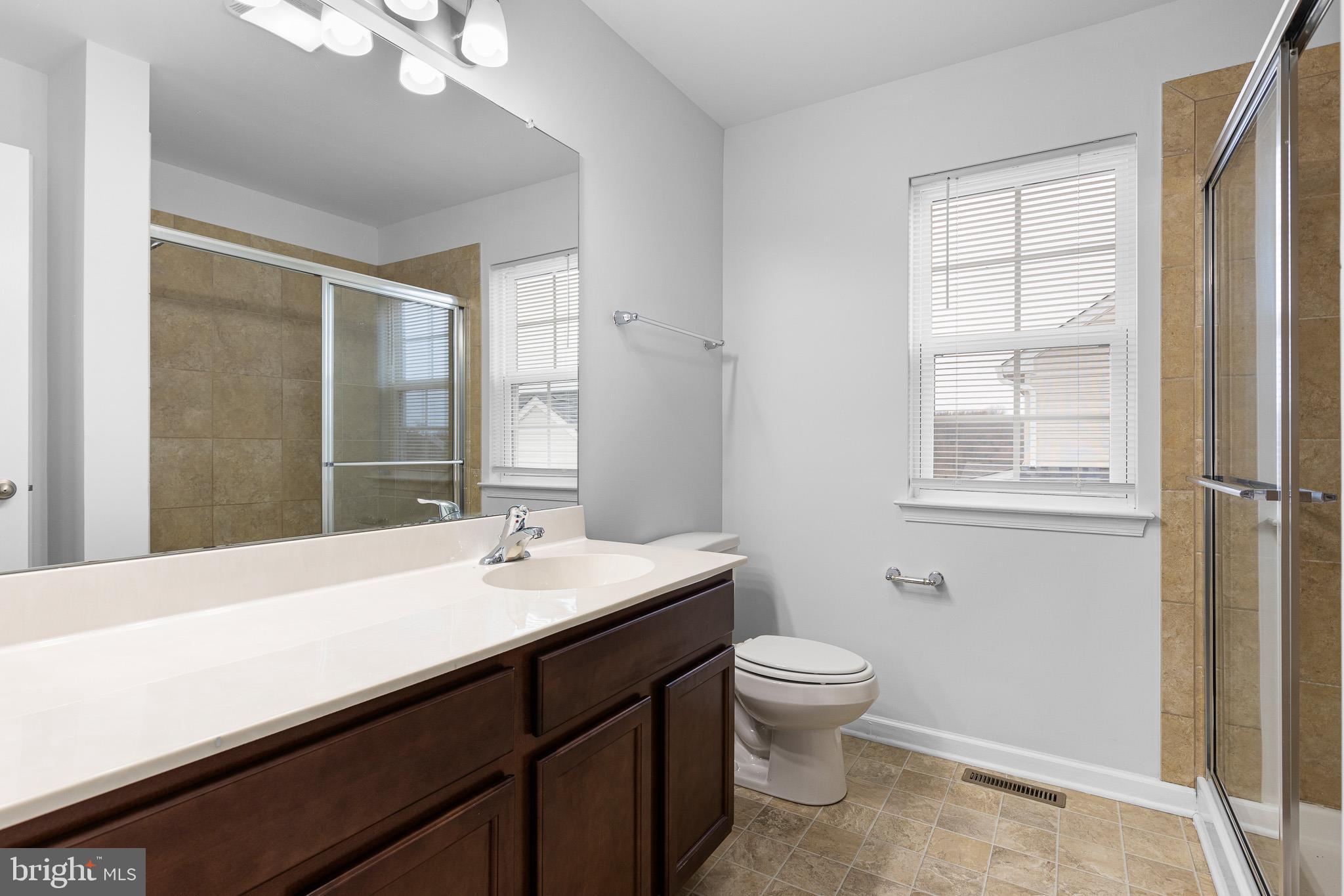 413 Janets Way Townsend, DE 19734 - Photo 17 of 27 a bathroom with a sink a toilet a mirror and a window